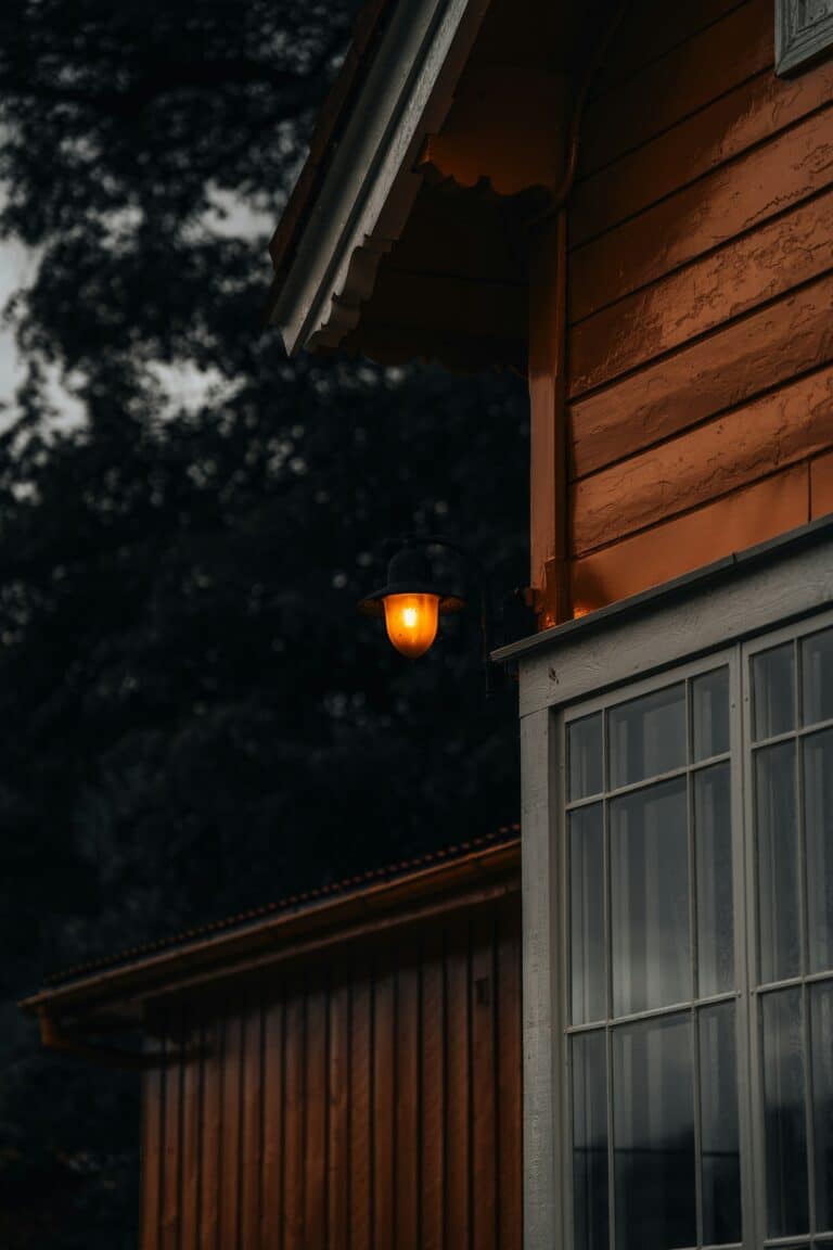 Home exterior glowing with warm light against a dark evening sky