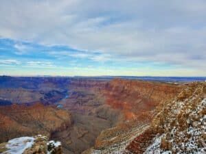 Red rock canyon walls dusted with snow under a blue winter sky