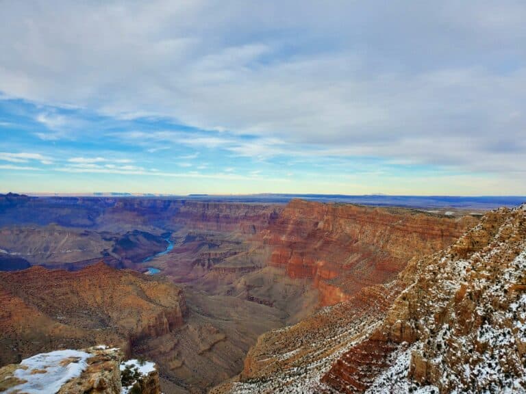 Red rock canyon walls dusted with snow under a blue winter sky