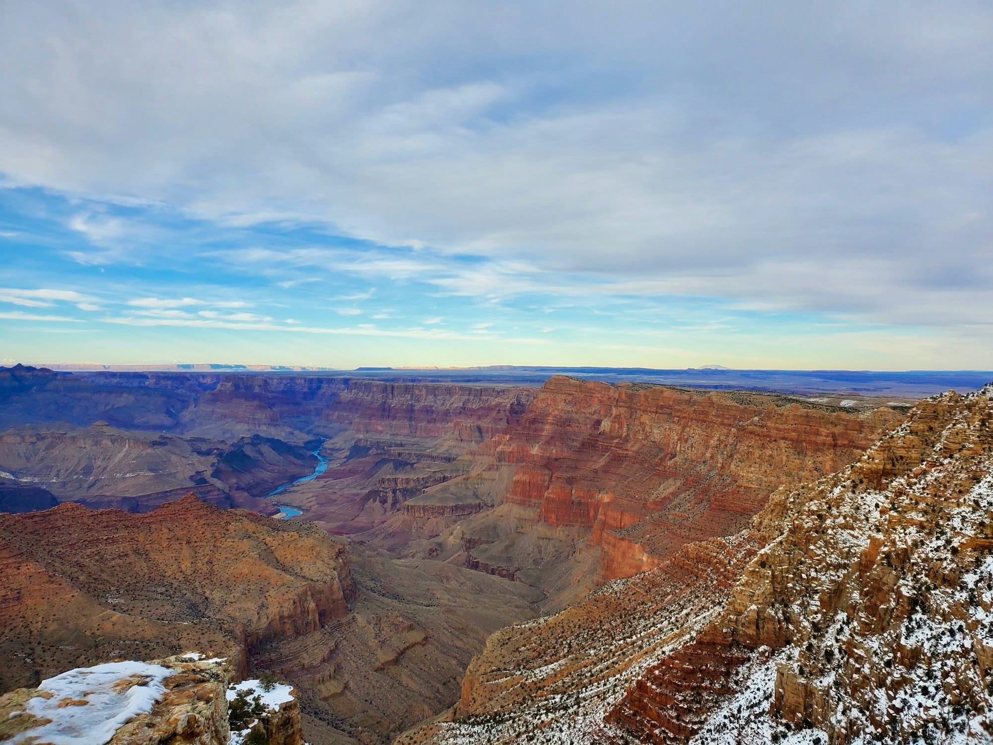 Red rock canyon walls dusted with snow under a blue winter sky
